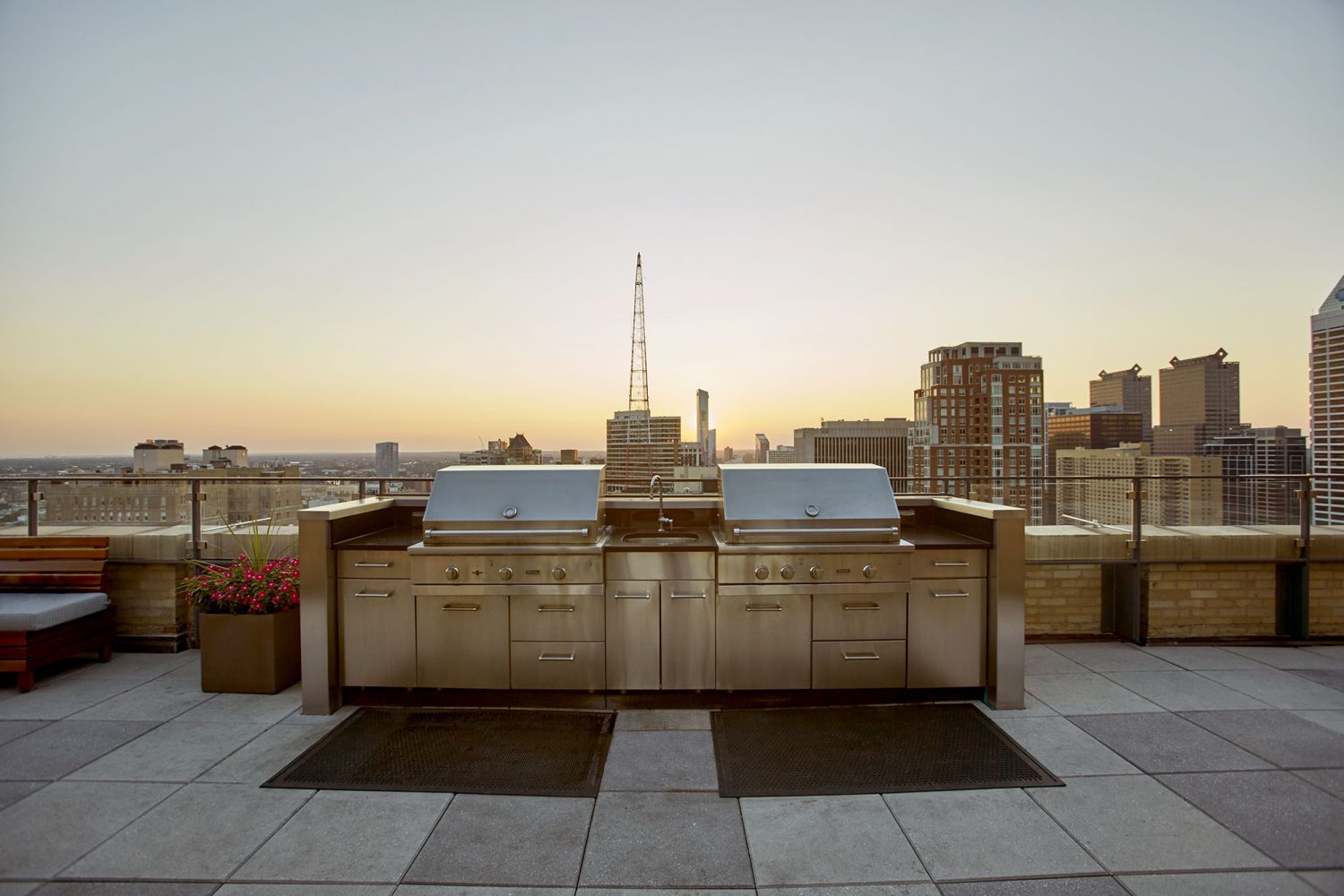 stainless steel gas grills on sky deck with sunset view of the city