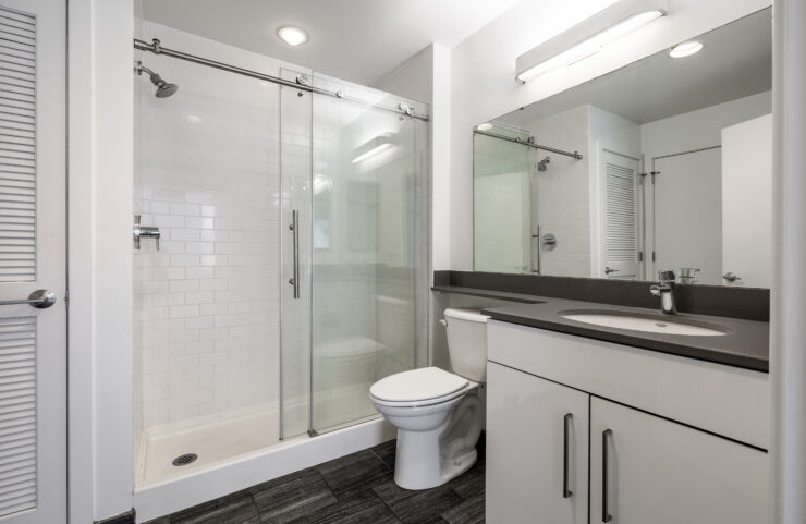 updated bathroom with white vanity and glass sliding door to shower