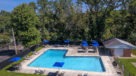 aerial view of pool with blue umbrella tables and chairs 