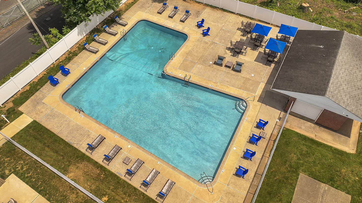 aerial view of pool with blue umbrella tables and chairs 