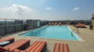rooftop pool with padded lounge chairs 