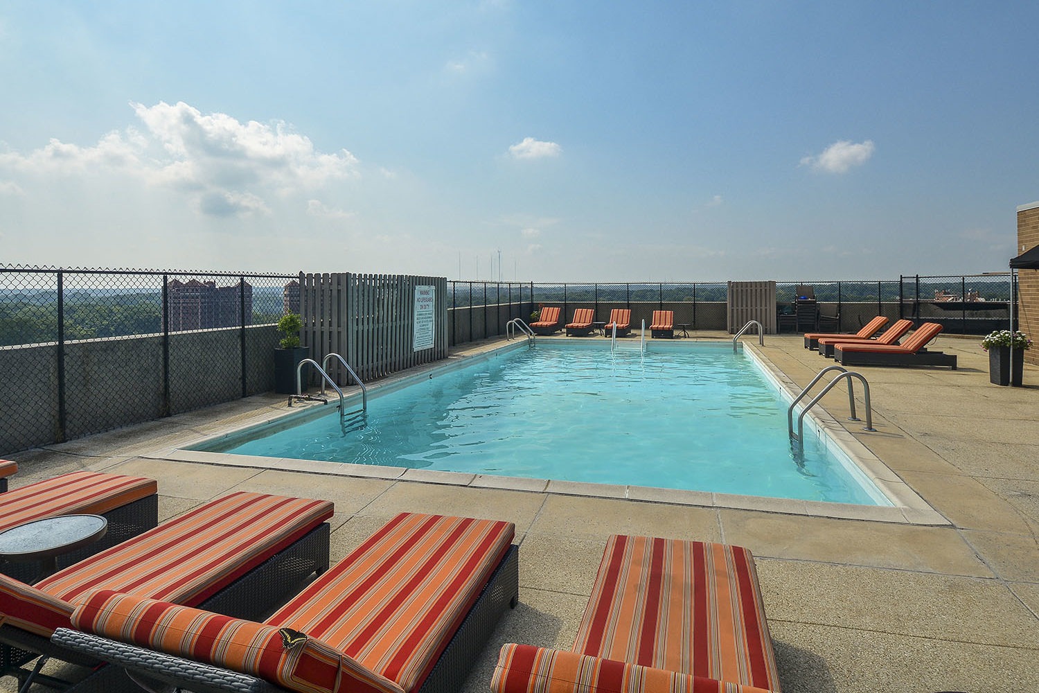 rooftop pool with padded lounge chairs 
