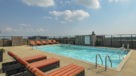 large rooftop pool with padded lounge chairs 