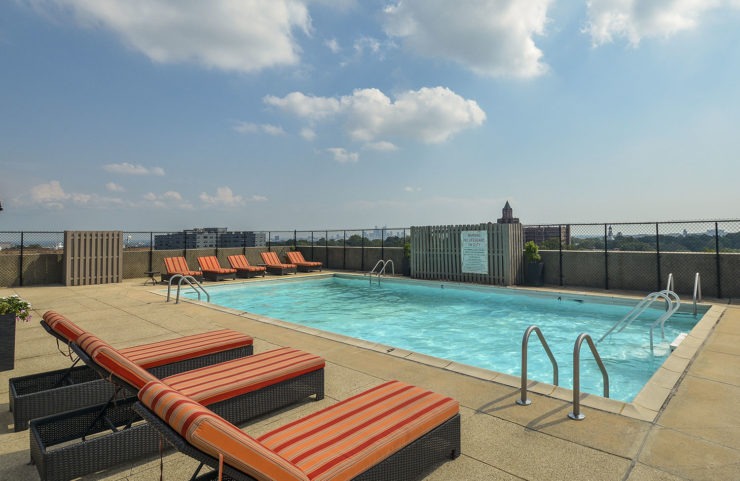 large rooftop pool with padded lounge chairs 