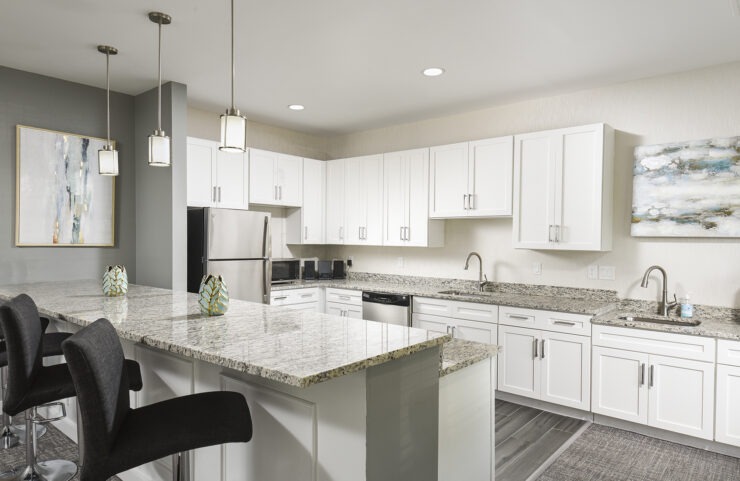 community room kitchen with an island with bar stools 