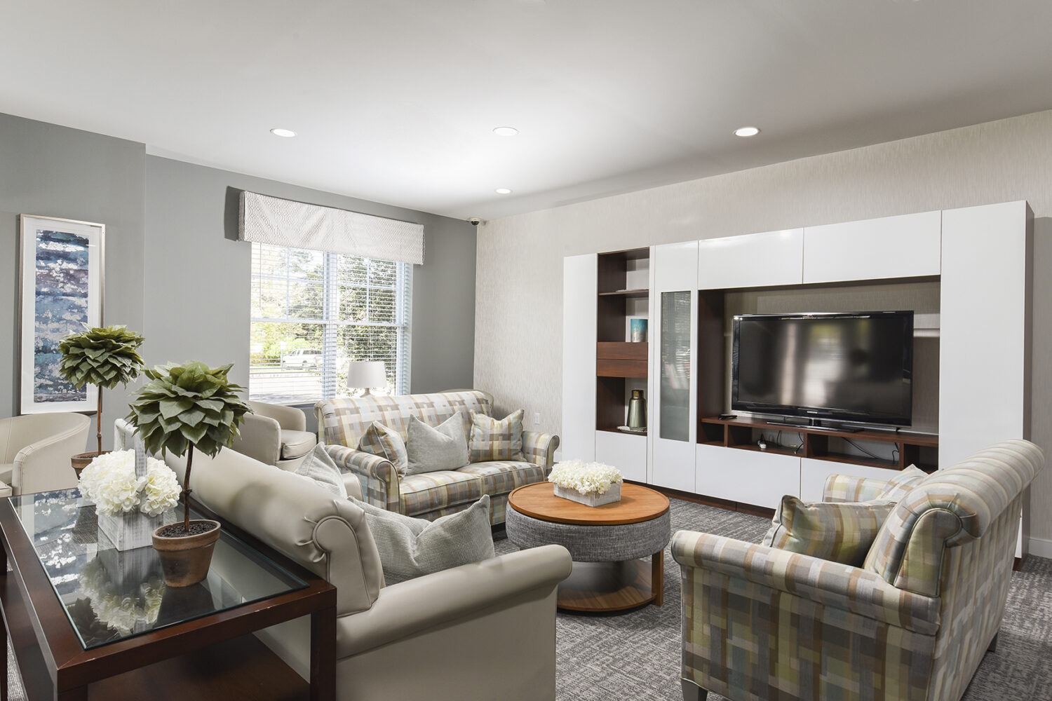 community room sofa with chairs and a large flat screen TV