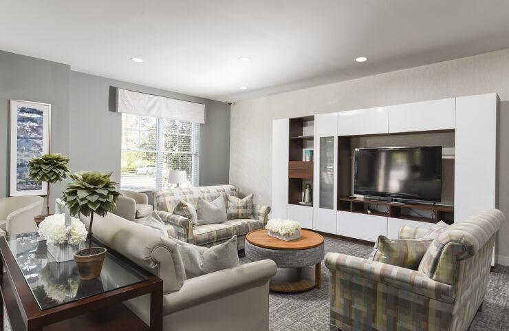 community room sofa with chairs and a large flat screen TV