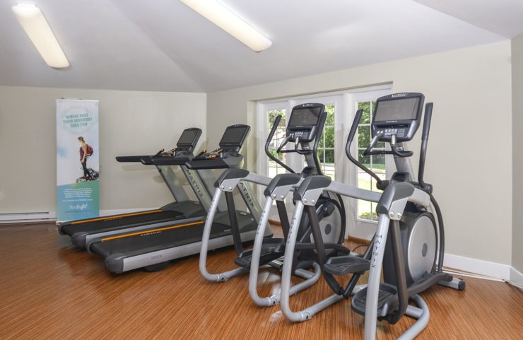 fitness center with treadmills and elliptical machines