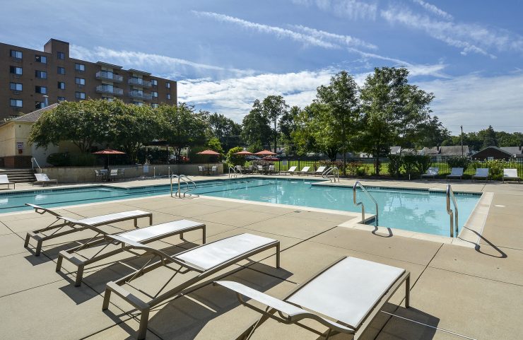 pool with lounge chairs and classic building in the background 