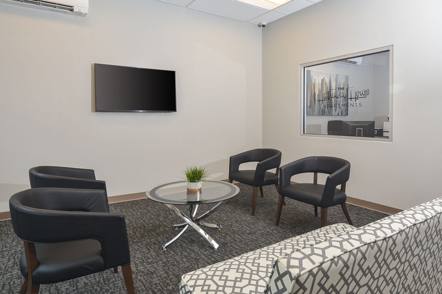leasing office with sofa, chairs and flat screen TV