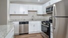 Penthouse kitchen with white cabinets and stainless steel appliances