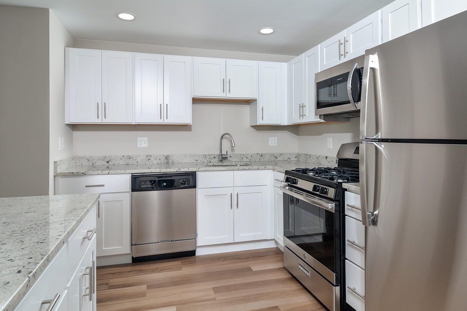 Penthouse kitchen with white cabinets and stainless steel appliances