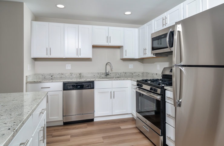 Penthouse kitchen with white cabinets and stainless steel appliances