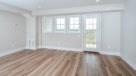 Penthouse living room with wood floors and access to balcony