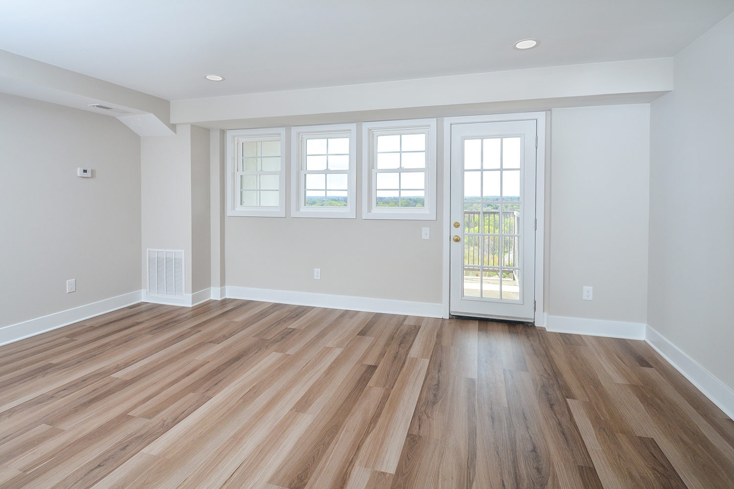 Penthouse living room with wood floors and access to balcony