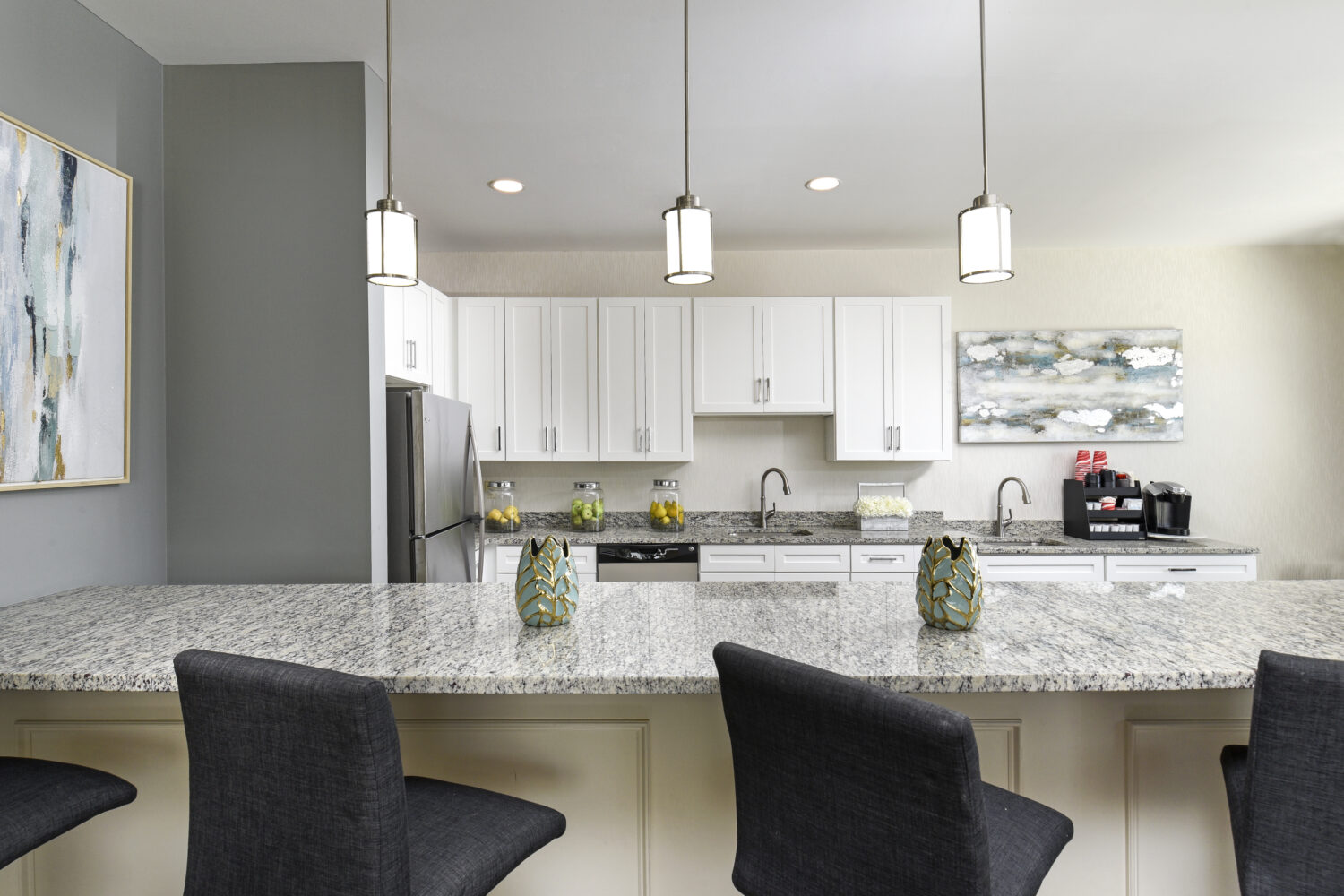 community room kitchen with an island with bar stools 