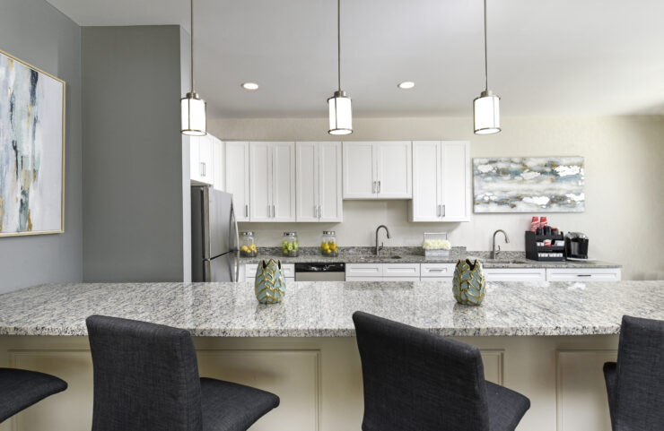 community room kitchen with an island with bar stools 