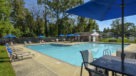umbrella tables and lounge chairs surround the pool 