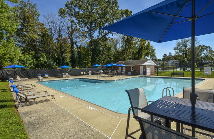 umbrella tables and lounge chairs surround the pool 
