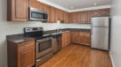 kitchen with medium tone wood cabinets, SS appliances and hardwood floors