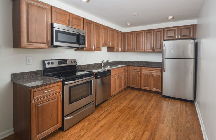 kitchen with medium tone wood cabinets, SS appliances and hardwood floors