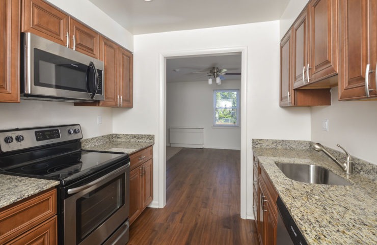Galley Style Kitchen with hardwood floors looking out into dining room