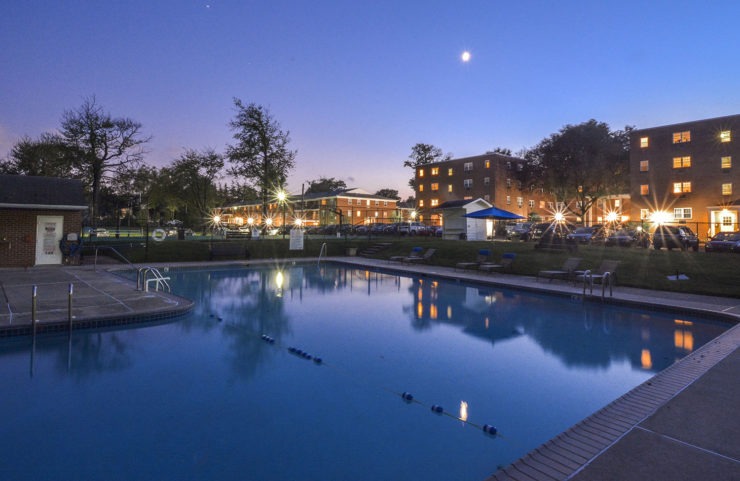 outdoor pool looking at buildings lit up at night