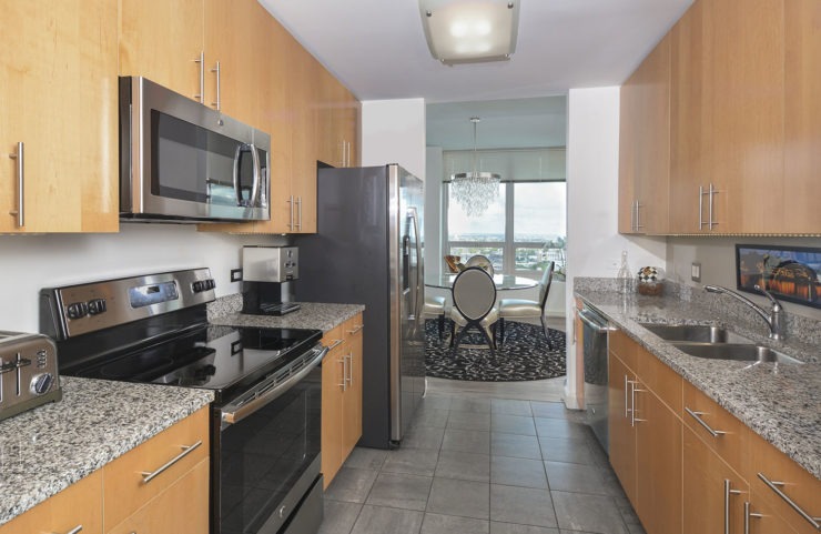 galley style kitchen with granite countertops and light wood cabinets