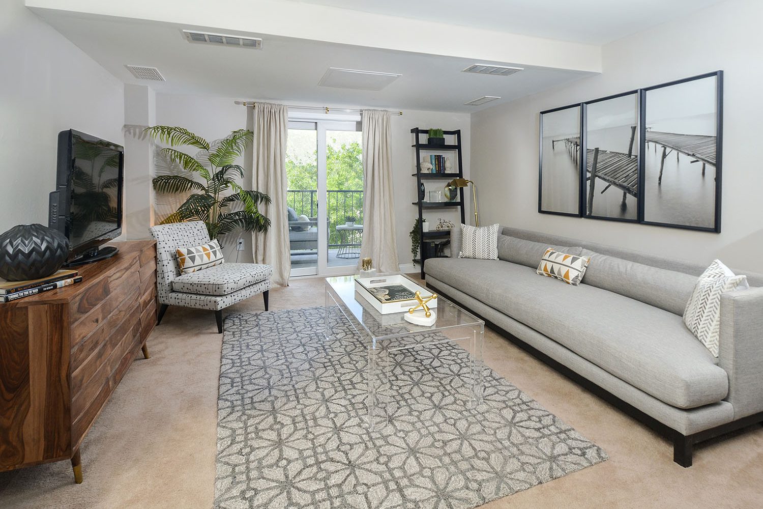 large living room with wall to wall carpet and sliding door out to private balcony 