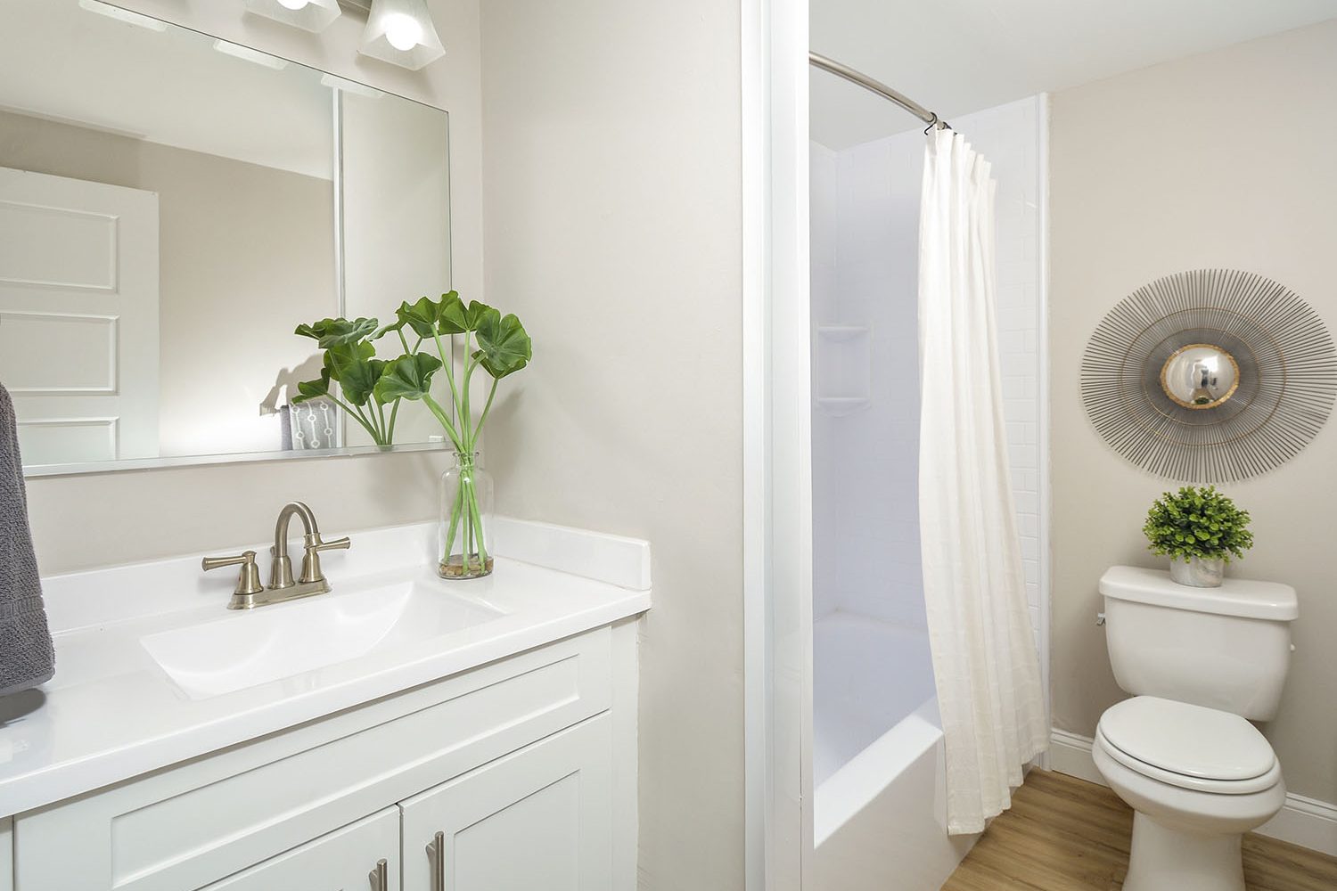 renovated bathroom with white vanity and tub 