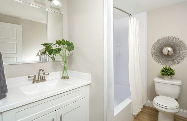 renovated bathroom with white vanity and tub 