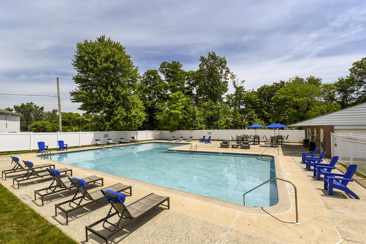 umbrella tables and lounge chairs surround the pool 