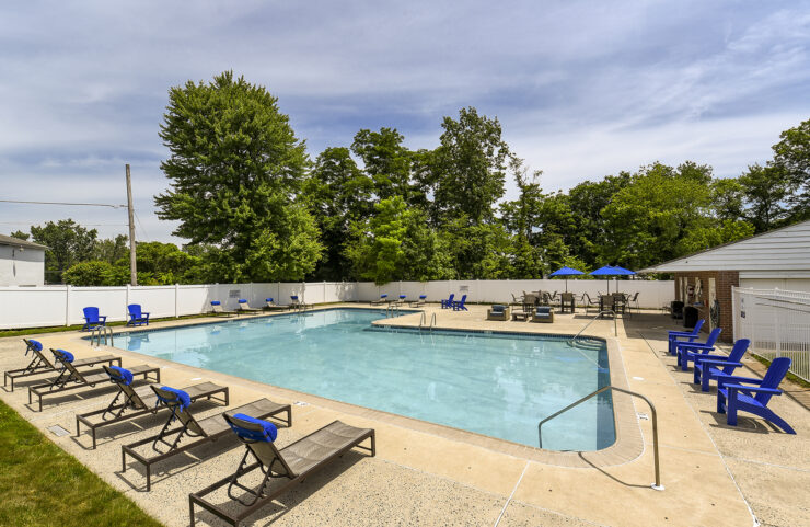 umbrella tables and lounge chairs surround the pool 