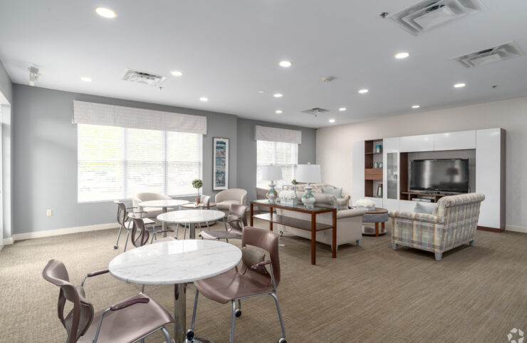 community room sofa with chairs and a large flat screen TV