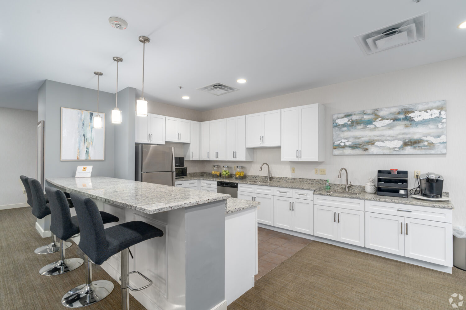 community room kitchen with an island with bar stools 