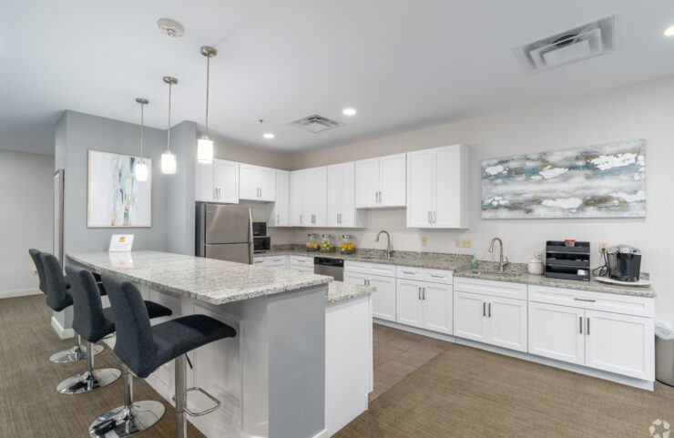 community room kitchen with an island with bar stools 