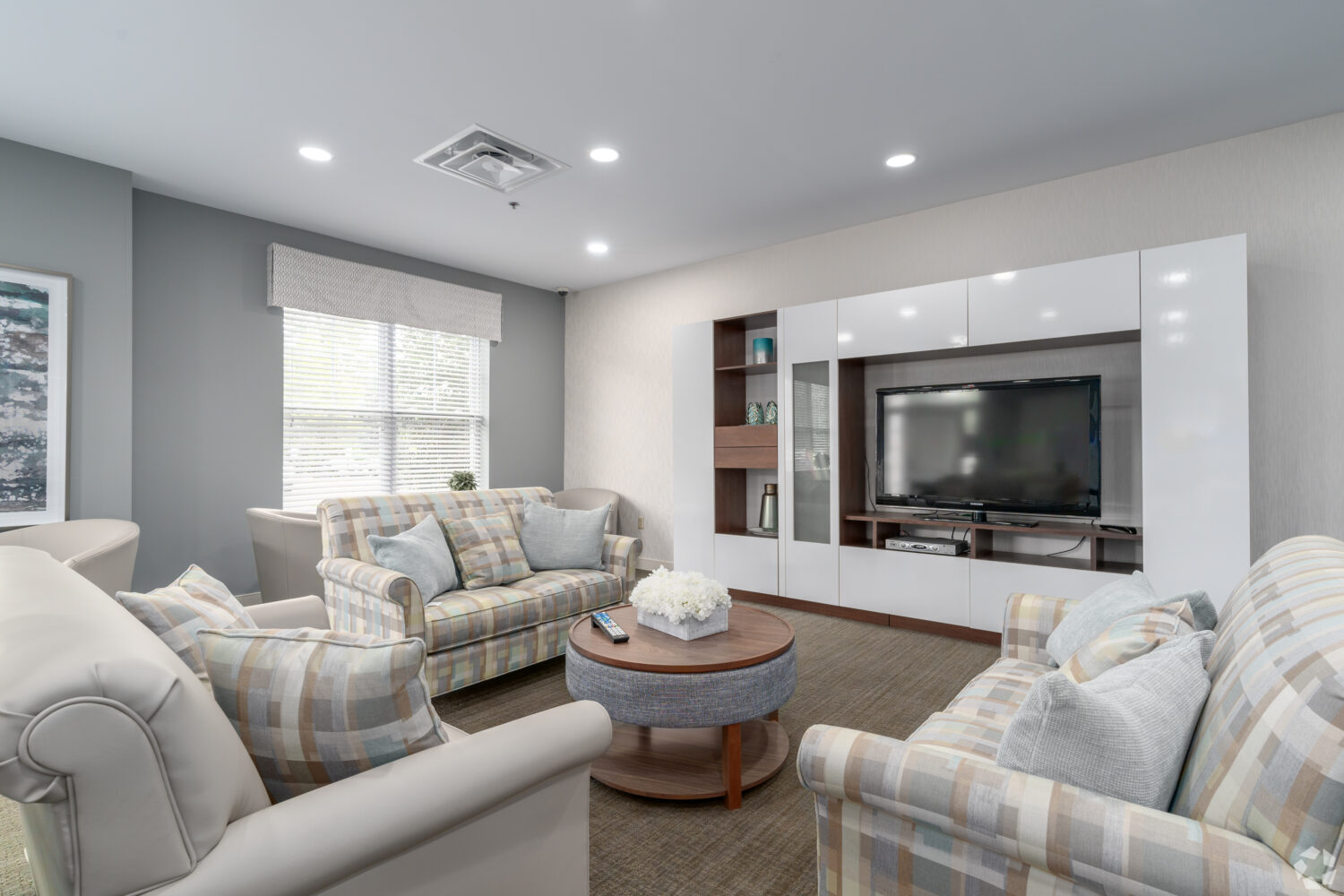 community room sofa with chairs and a large flat screen TV