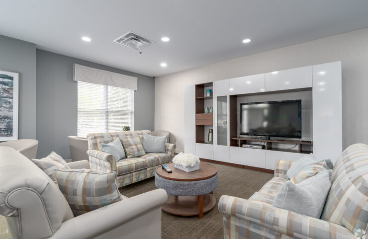 community room sofa with chairs and a large flat screen TV