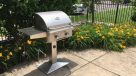 stainless steel grill surrounded by flowers 