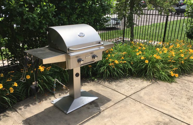 stainless steel grill surrounded by flowers 