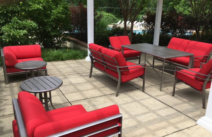 poolside pergola with red padded chairs 