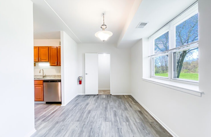 dining area with large window and plank flooring