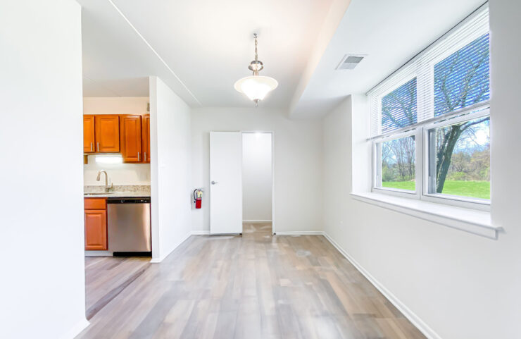 dining area with large window and plank flooring