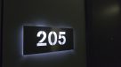 sleek back lit apartment number plates in hallway 