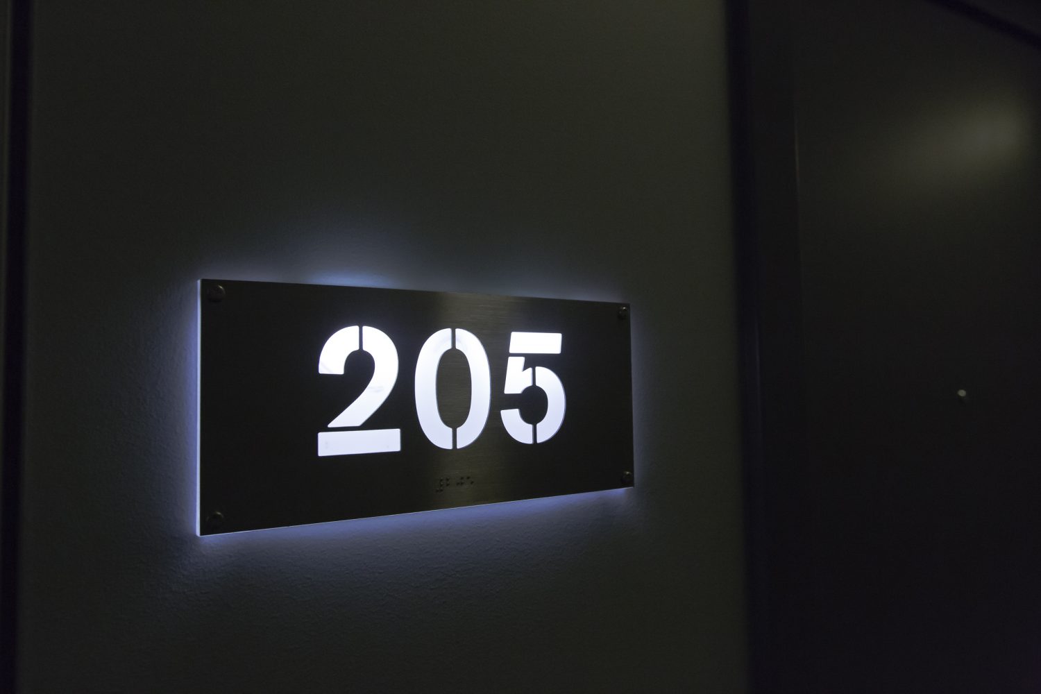 sleek back lit apartment number plates in hallway