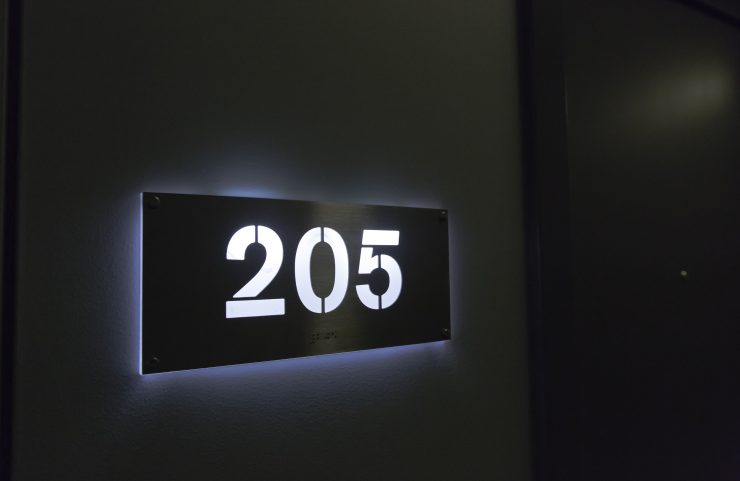 sleek back lit apartment number plates in hallway 