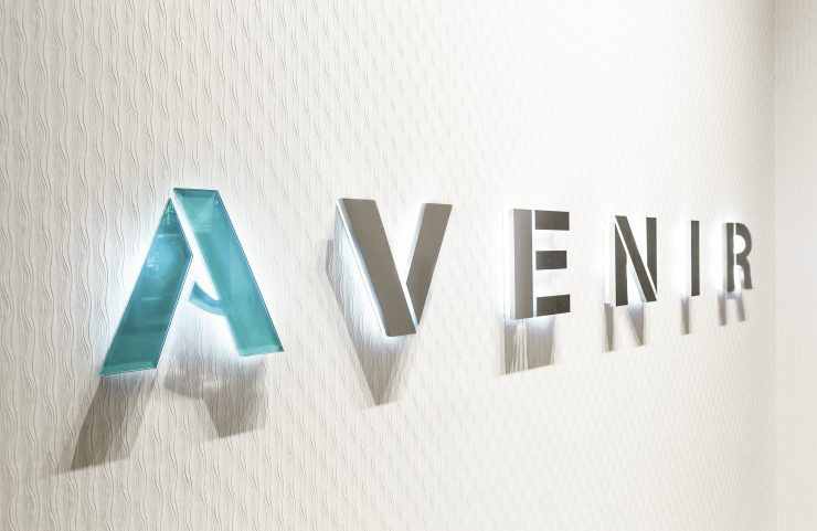 backlit Avenir sign on wall in lobby