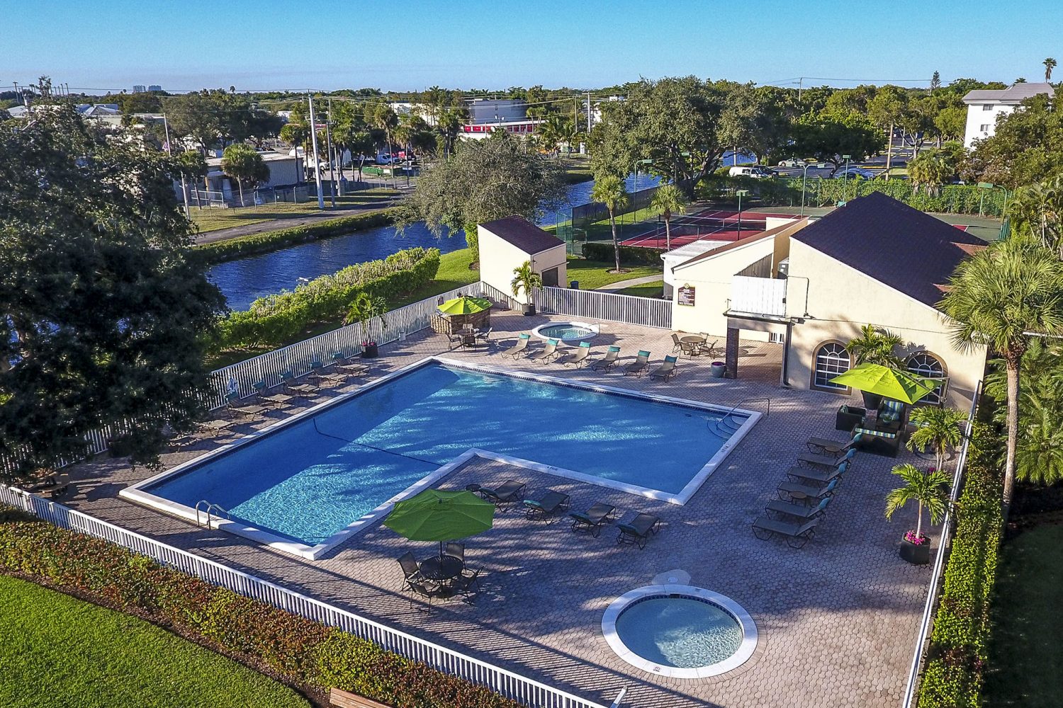 aerial photo of the pool and jacuzzi right next to a lake 