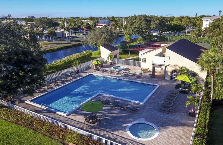 aerial photo of the pool and jacuzzi right next to a lake 