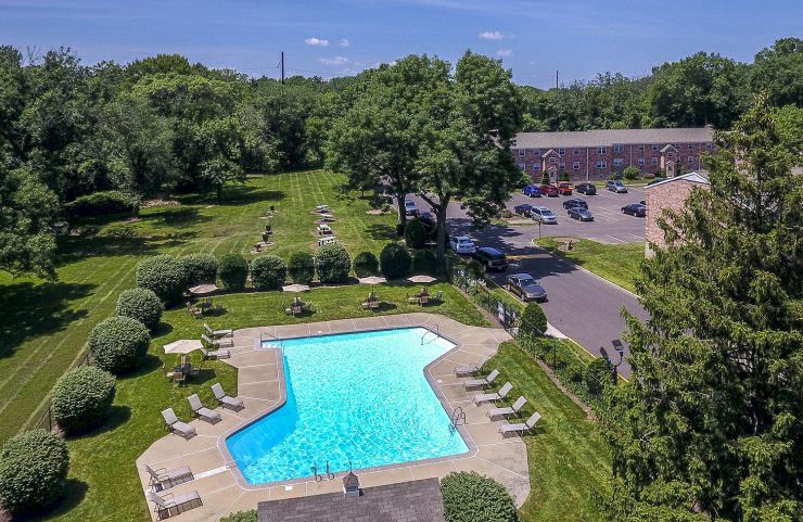 aerial view of outdoor pool with apartment in background 